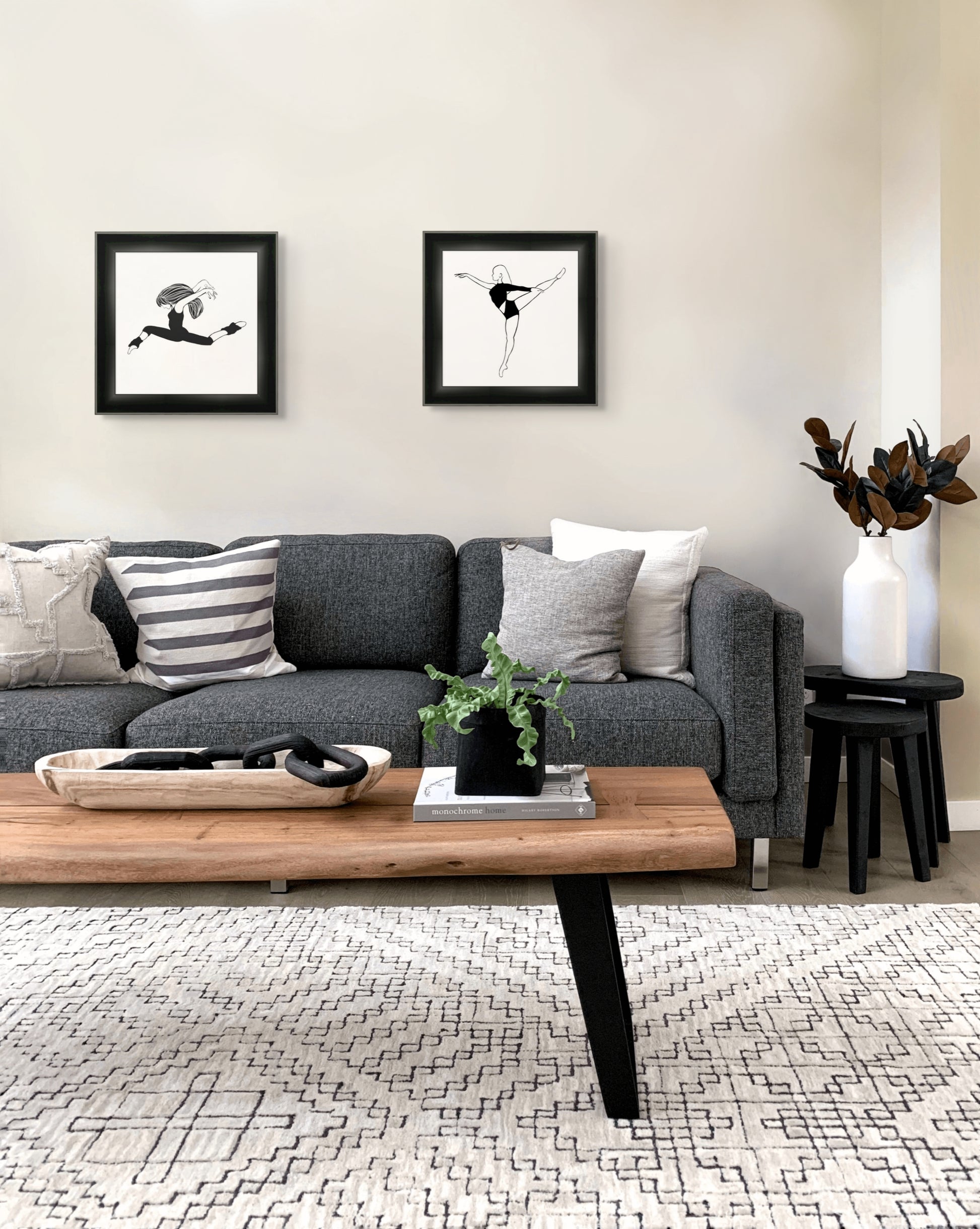 Living room with a gray sofa, wooden coffee table, and black and white artwork of dancers.